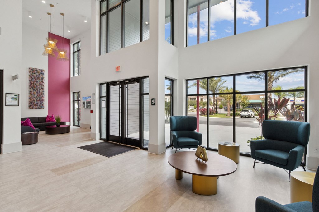A large room with a pink wall and a glass doorat Pinnacle Apartments, Jacksonville, FL
