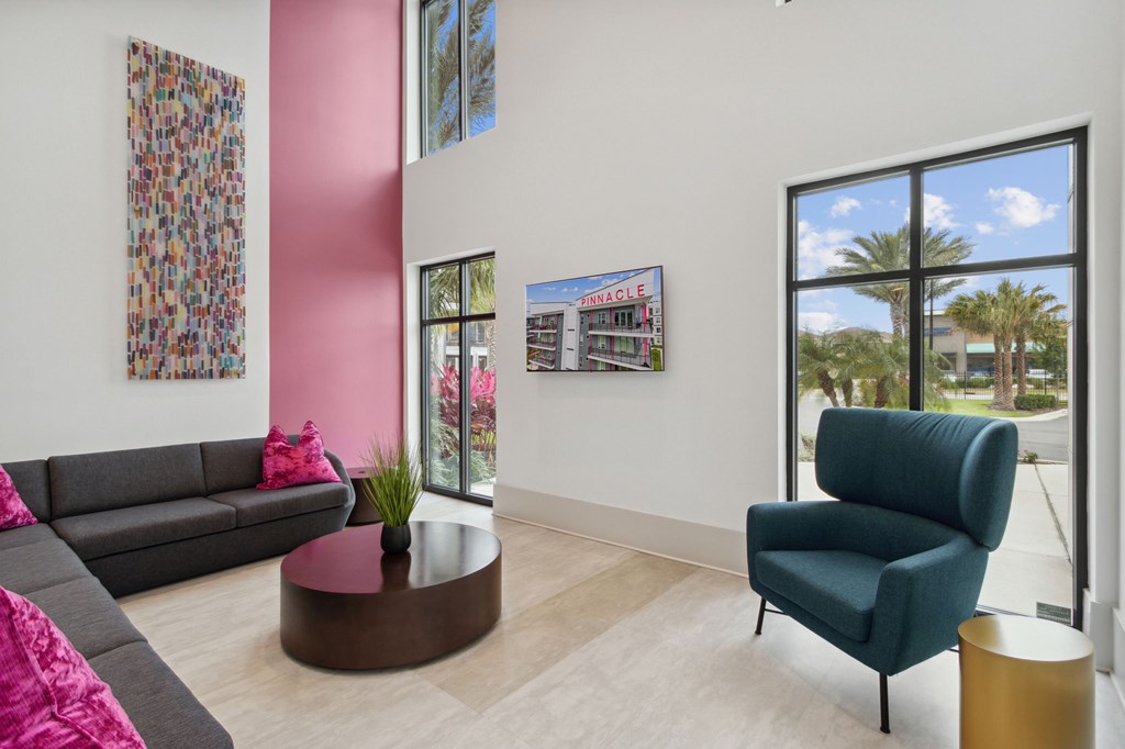 A living room with a grey sofa, a green armchair, and a coffee table.at Pinnacle Apartments, Jacksonville, FL