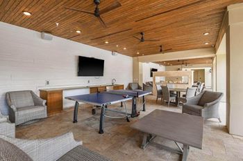 a room with a ping pong table and chairs  at Palm Bay Club, Jacksonville, 32258