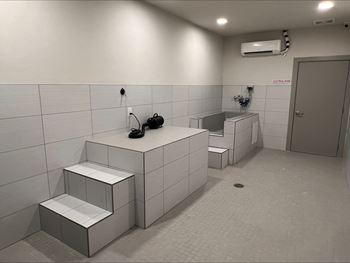 a bathroom with two urinals and a sink and a door at Pinnacle Apartments, Jacksonville, 32256