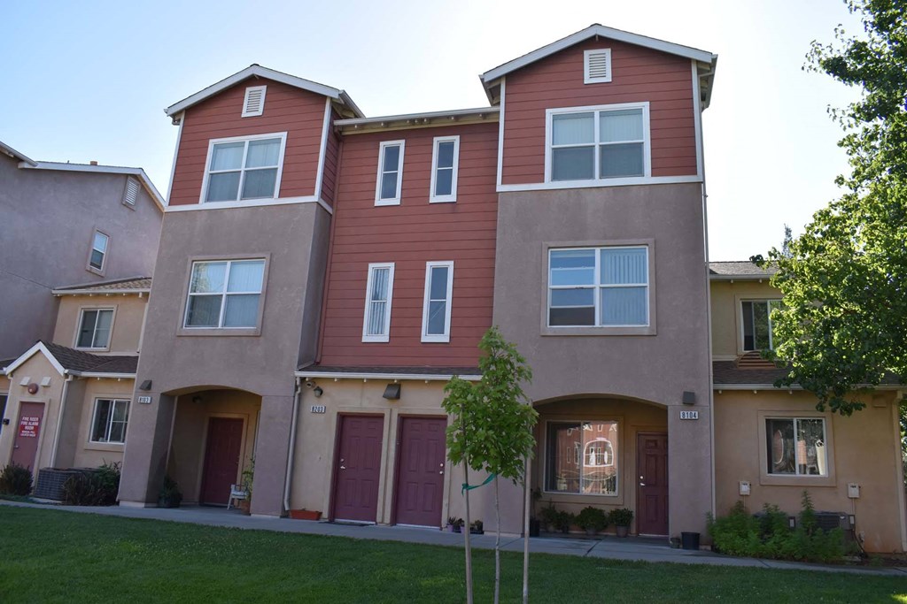 an apartment building with a yard in front of it