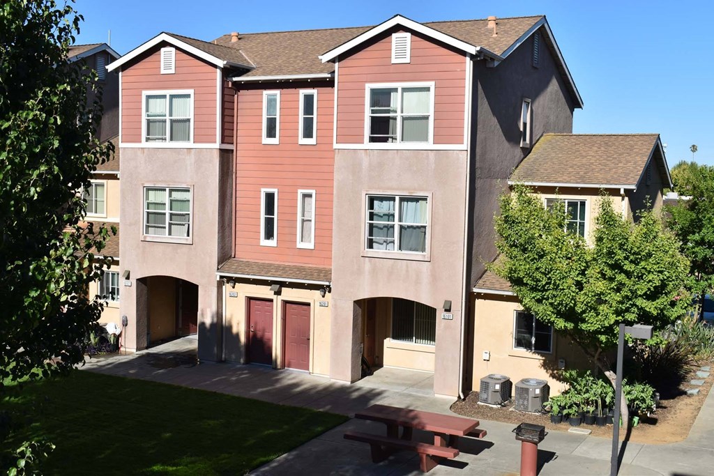 an apartment building with a picnic table in front of it