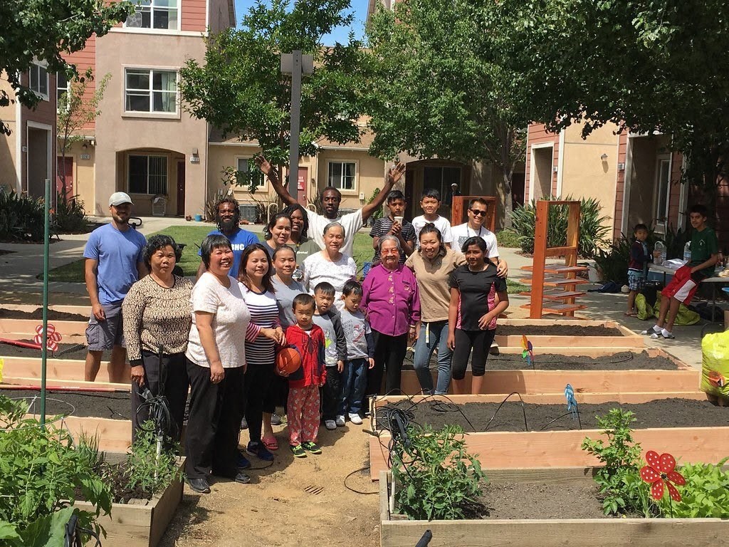 a group of people posing for a picture in a garden