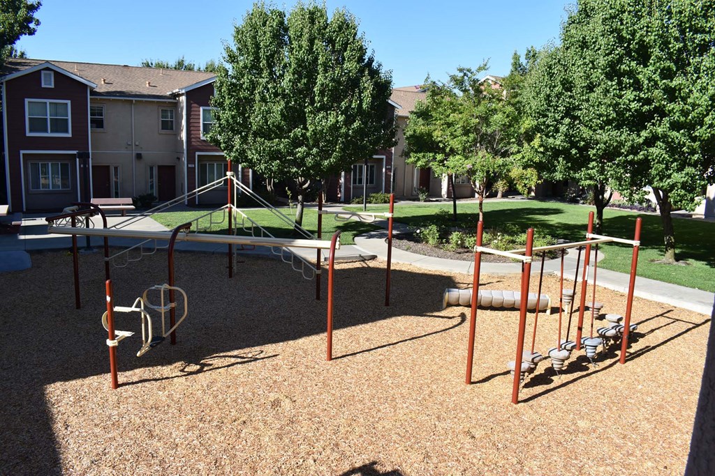 an empty playground in front of an apartment complex