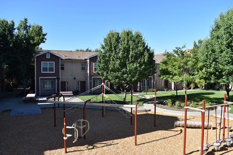 an empty playground in front of an apartment complex