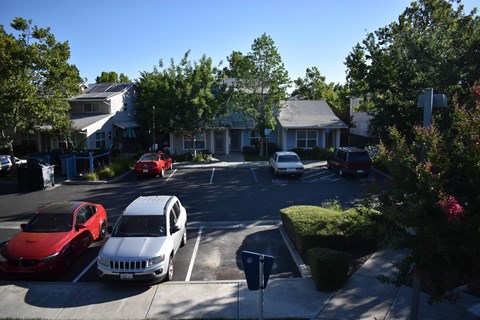 A residential street with cars parked on both sides.