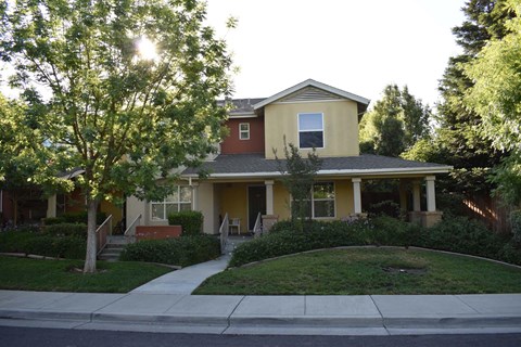 A house with a red roof and a yellow front.