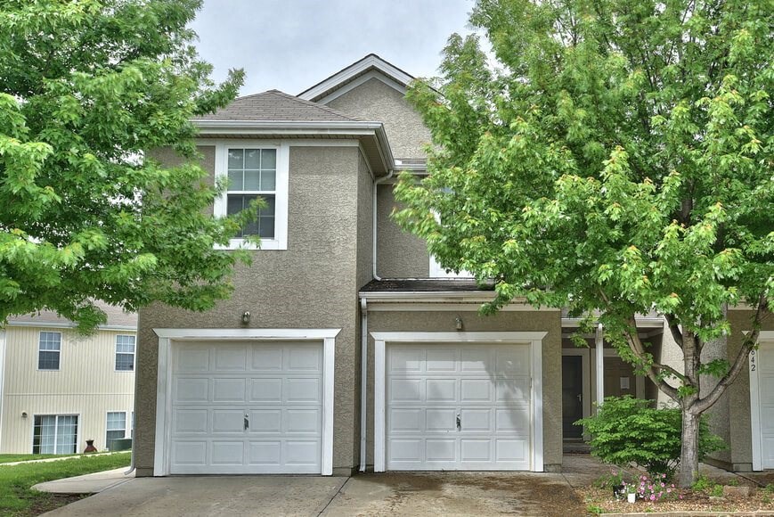 a house with two garage doors in front of it