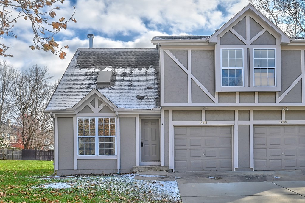 A house with a grey roof and a garage door.