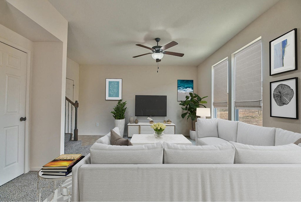 a living room with a white couch and a ceiling fan