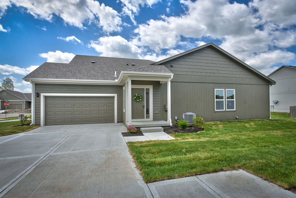 A house with a grey garage door and a grey roof.