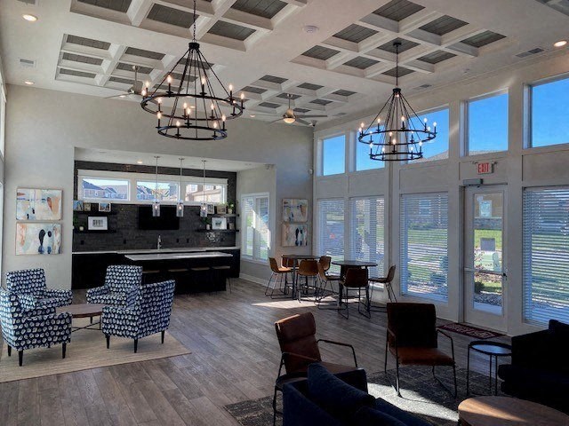 a lobby with chairs and a bar and chandeliers