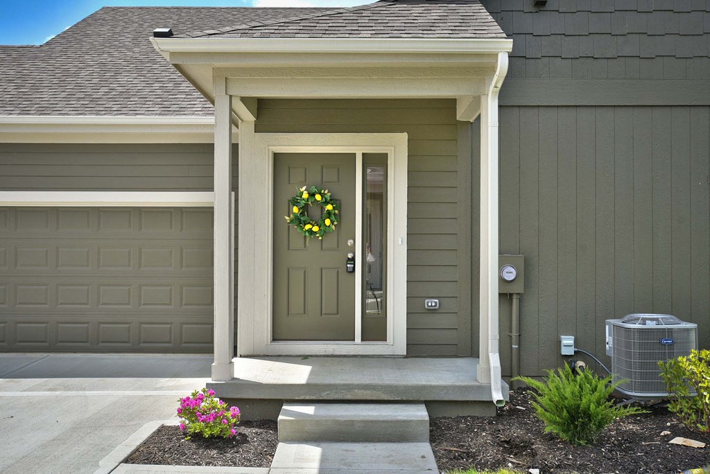 A house with a brown door and a wreath on it.