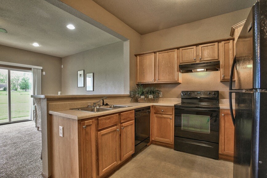 a kitchen with black appliances and wooden cabinets