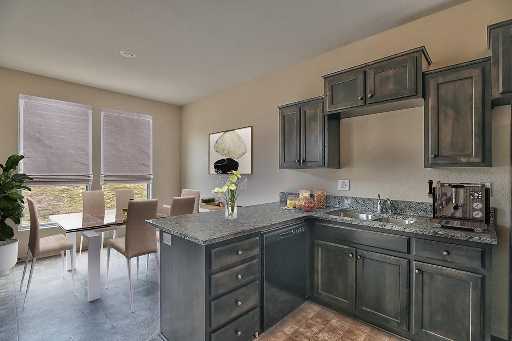 a kitchen with a sink and a table with chairs
