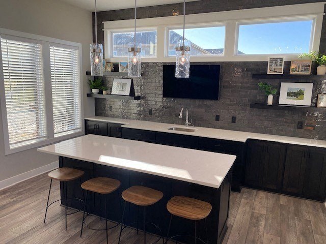 a kitchen with a white counter top and three stools