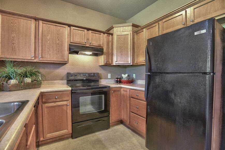 a kitchen with black appliances and wooden cabinets
