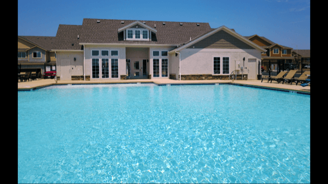 a large swimming pool in front of a house