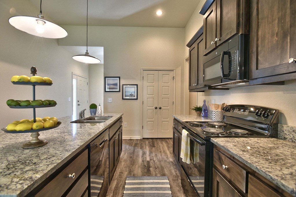 a large kitchen with granite counter tops and stainless steel appliances