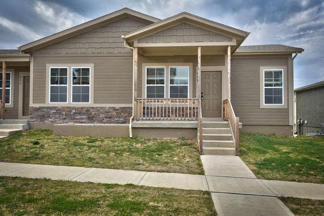 a brown house with a front porch and stairs