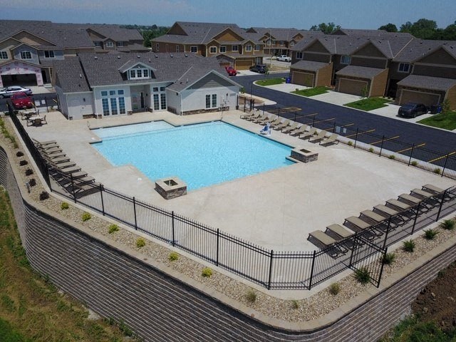 an aerial view of a swimming pool with chairs around it