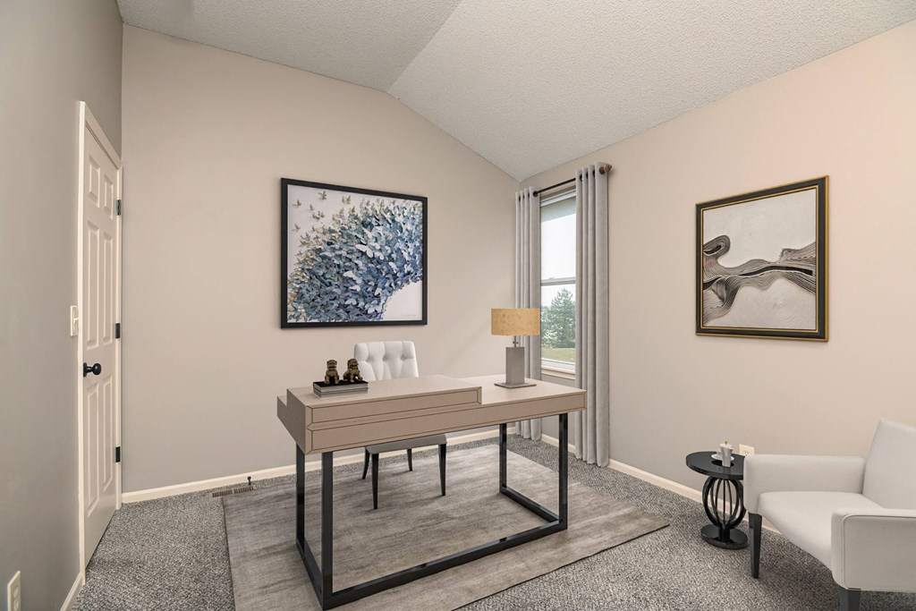 a living room with a desk and a window