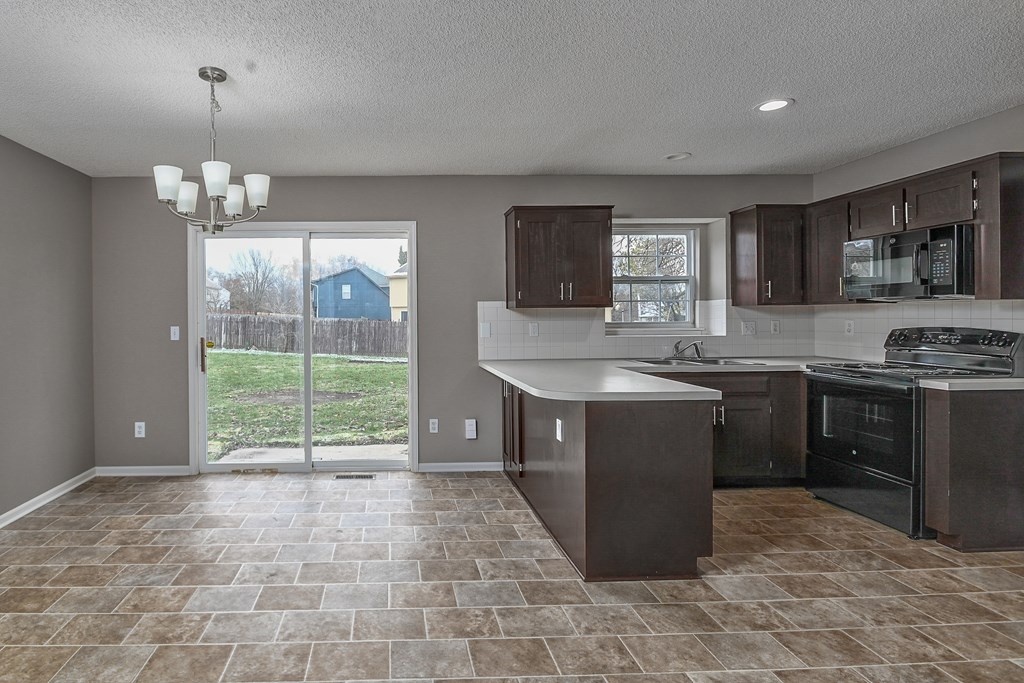 A kitchen with brown cabinets and a tiled floor.