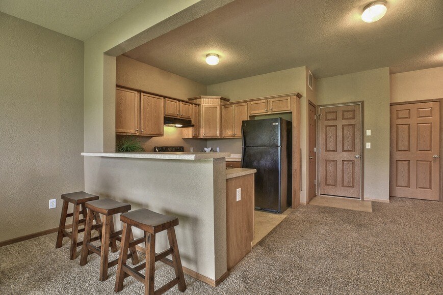 a kitchen with a bar and a refrigerator