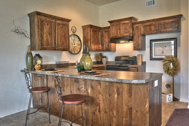 a kitchen with a bar with two chairs