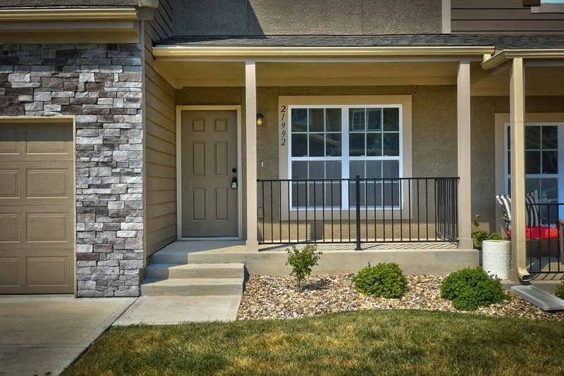 a front door of a house with a porch and stairs