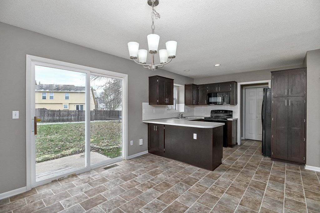 A kitchen with brown cabinets and a tiled floor.