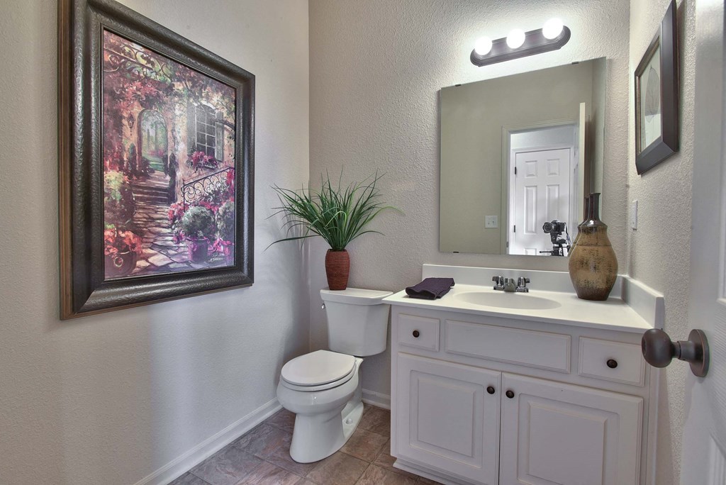a bathroom with a toilet sink and a mirror