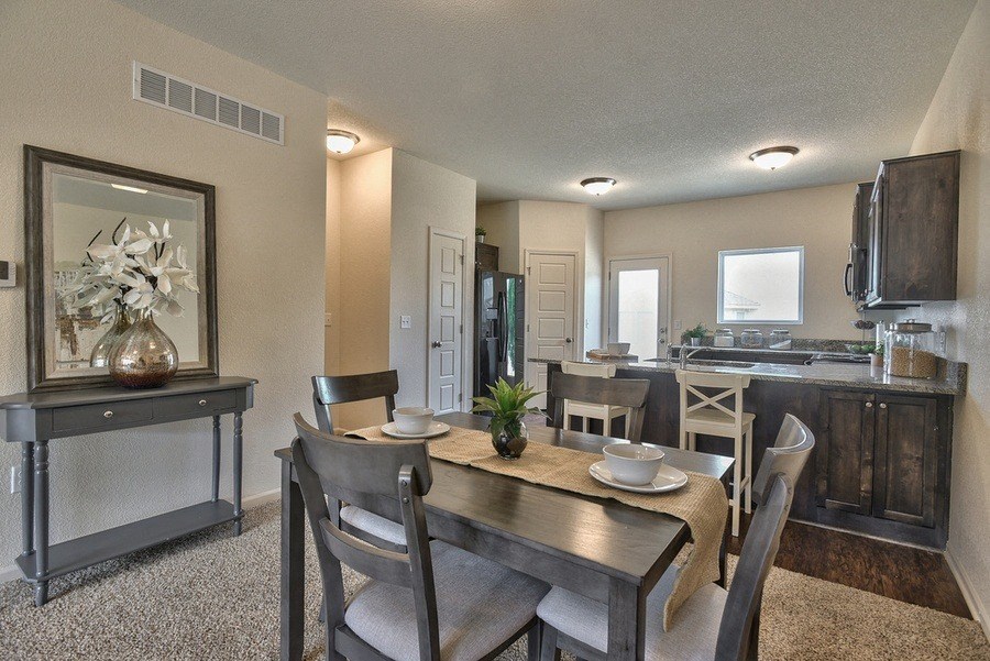 a dining room with a table and chairs next to a kitchen