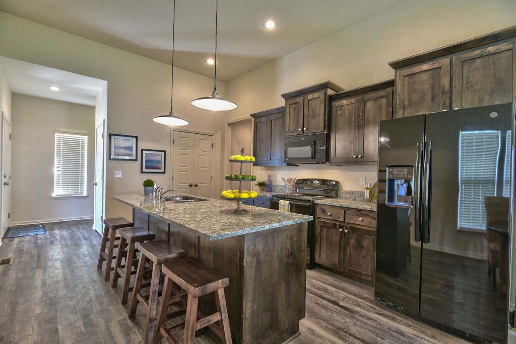 A kitchen with wooden cabinets and a granite countertop.