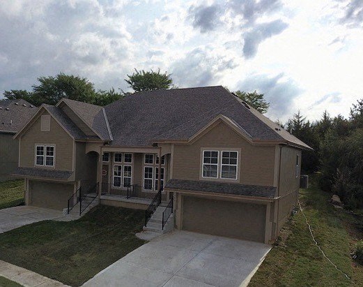 a brown house with a sidewalk in front of it