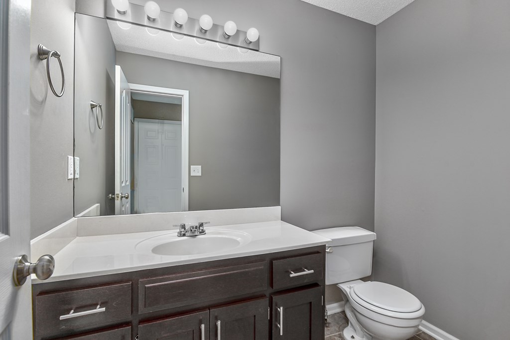 A bathroom with a white sink and a toilet.