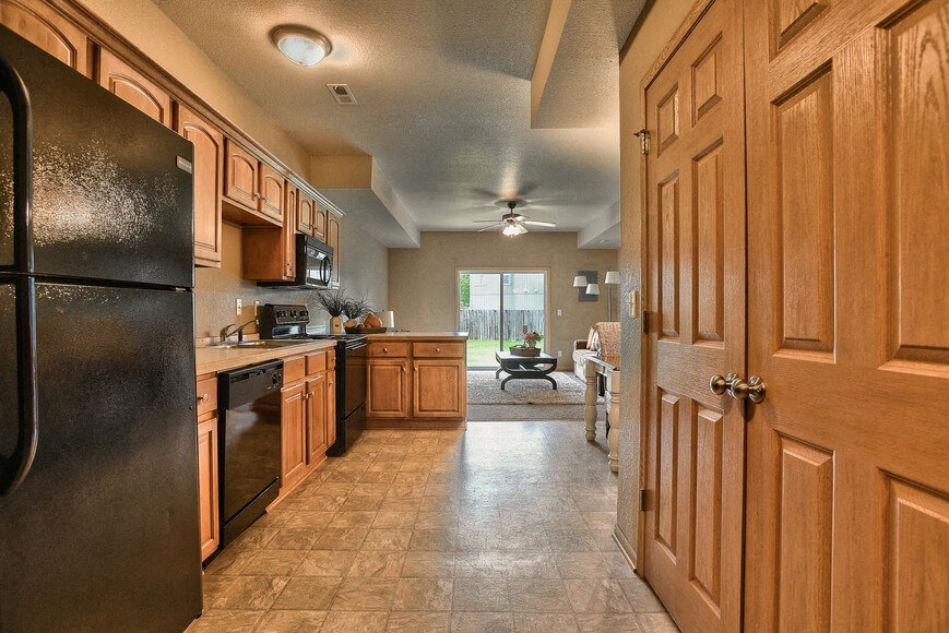 a large kitchen with wooden cabinets and stainless steel appliances