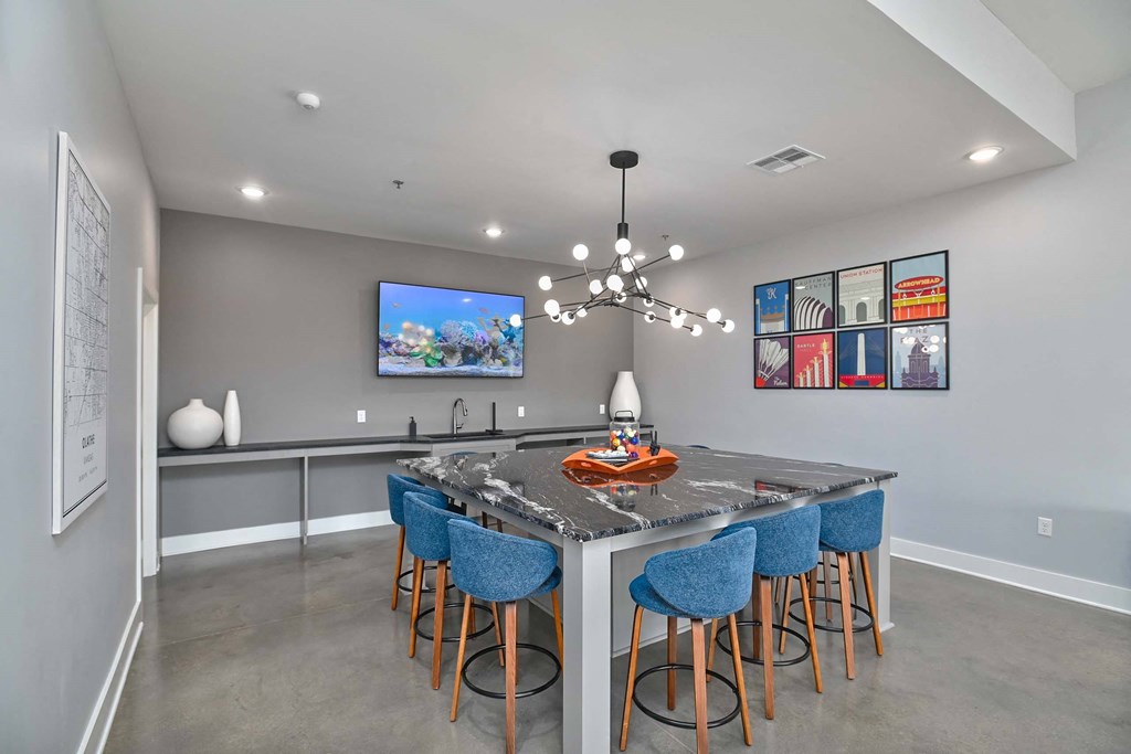 a kitchen with a bar and blue chairs
