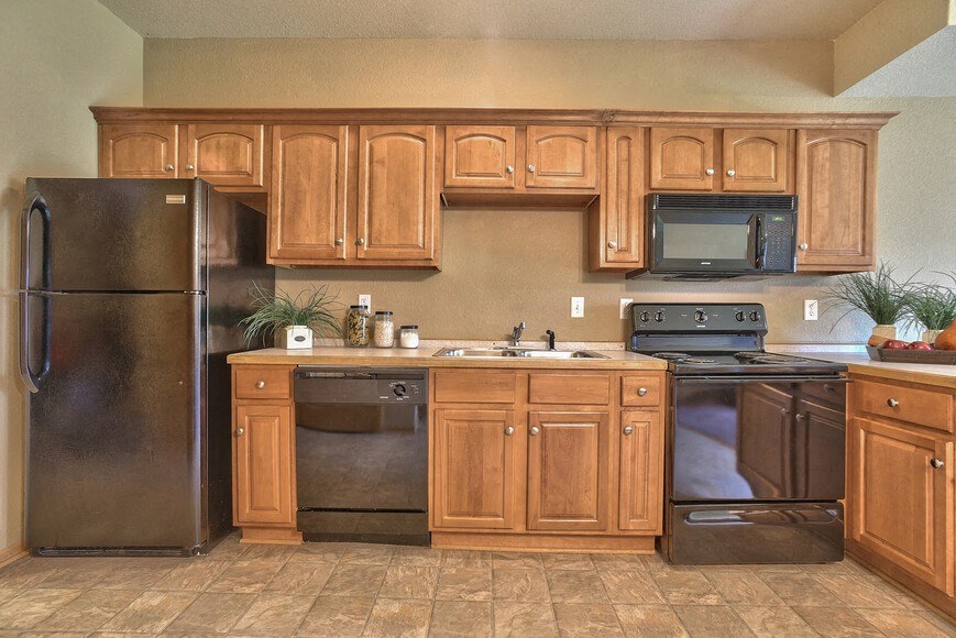 a kitchen with wooden cabinets and stainless steel appliances