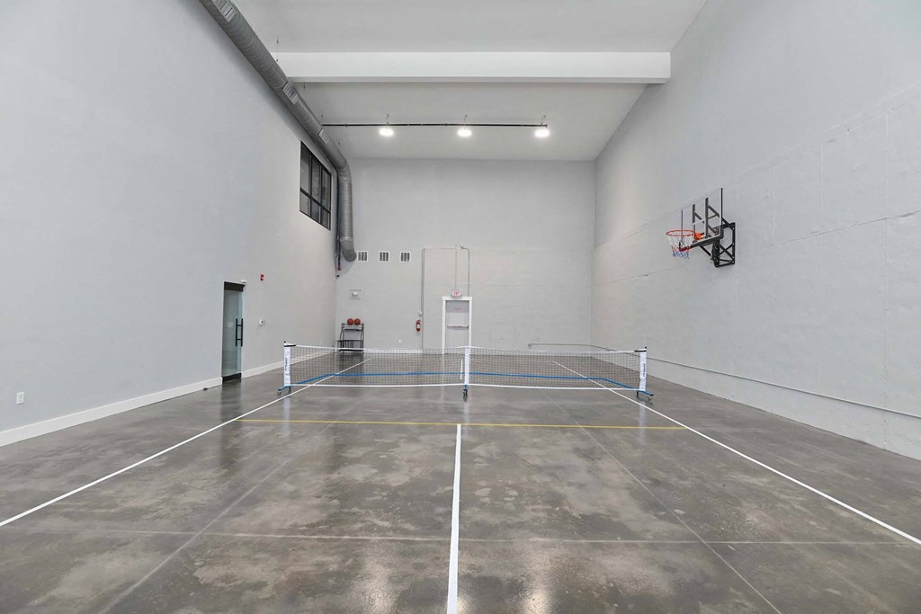 a tennis court in a white room with a net in the middle