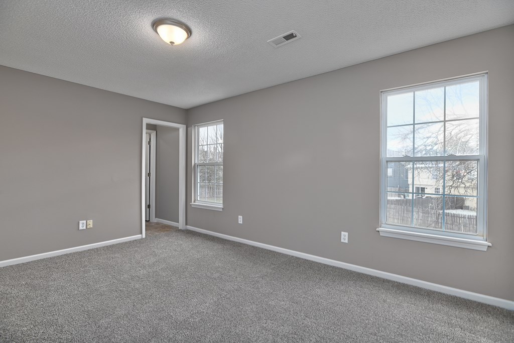 A room with a carpeted floor and a window.
