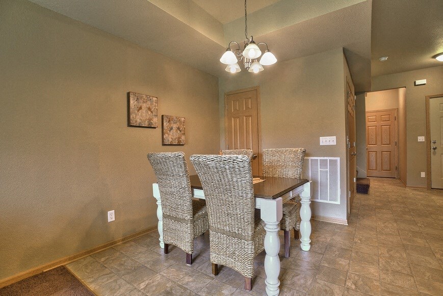 the dining room has a table and chairs and a chandelier