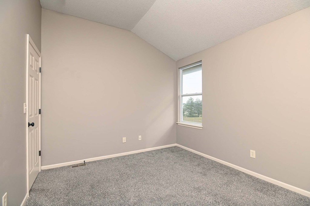 an empty room with carpet and a window