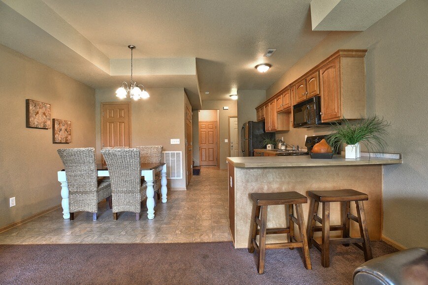 a dining room with a bar and stools in a house