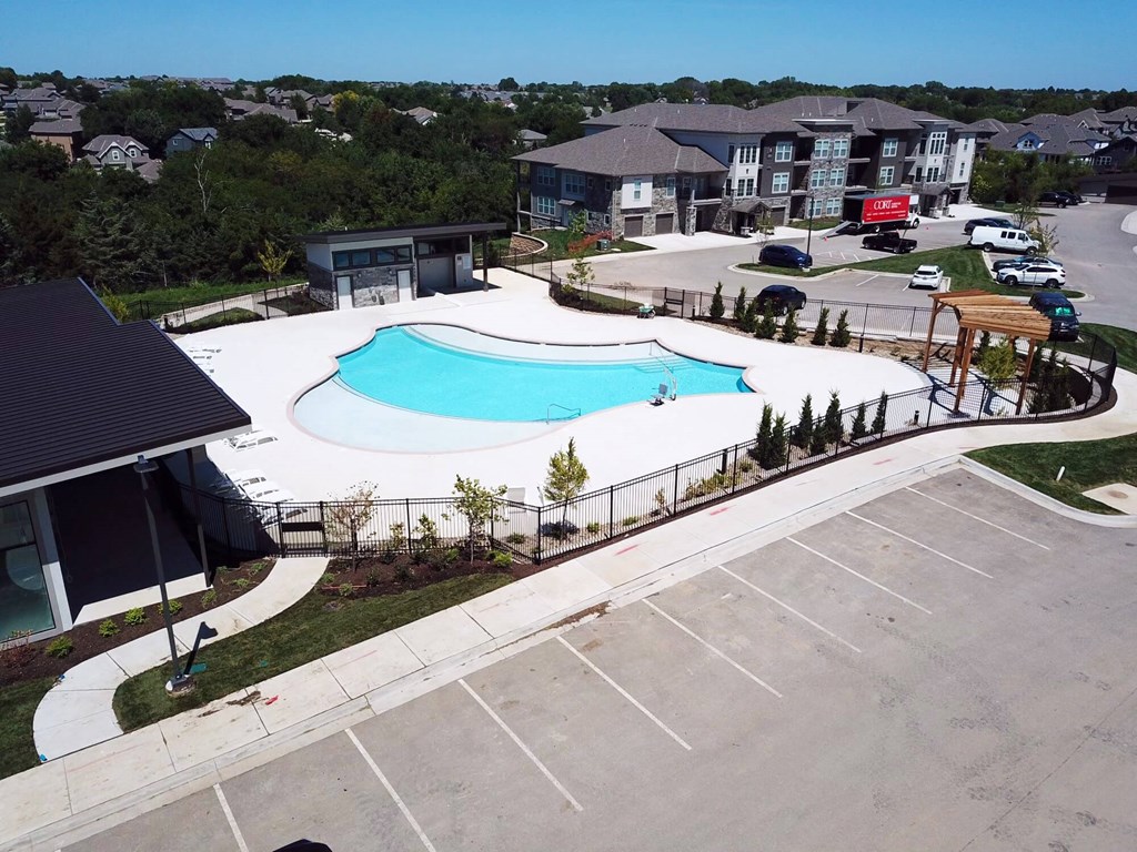 an aerial view of a swimming pool in front of a building