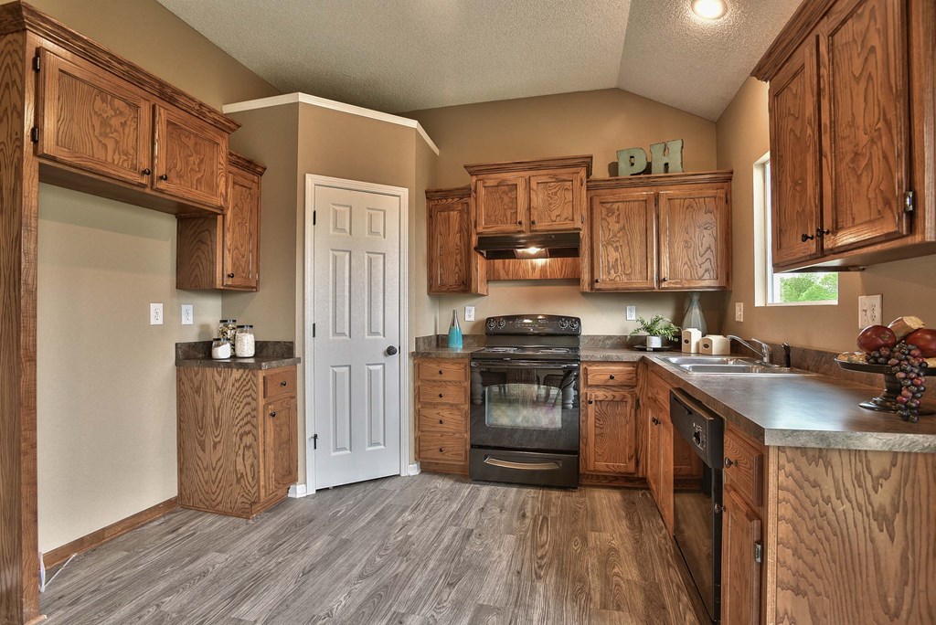 a kitchen with wooden cabinets and a stove and a sink