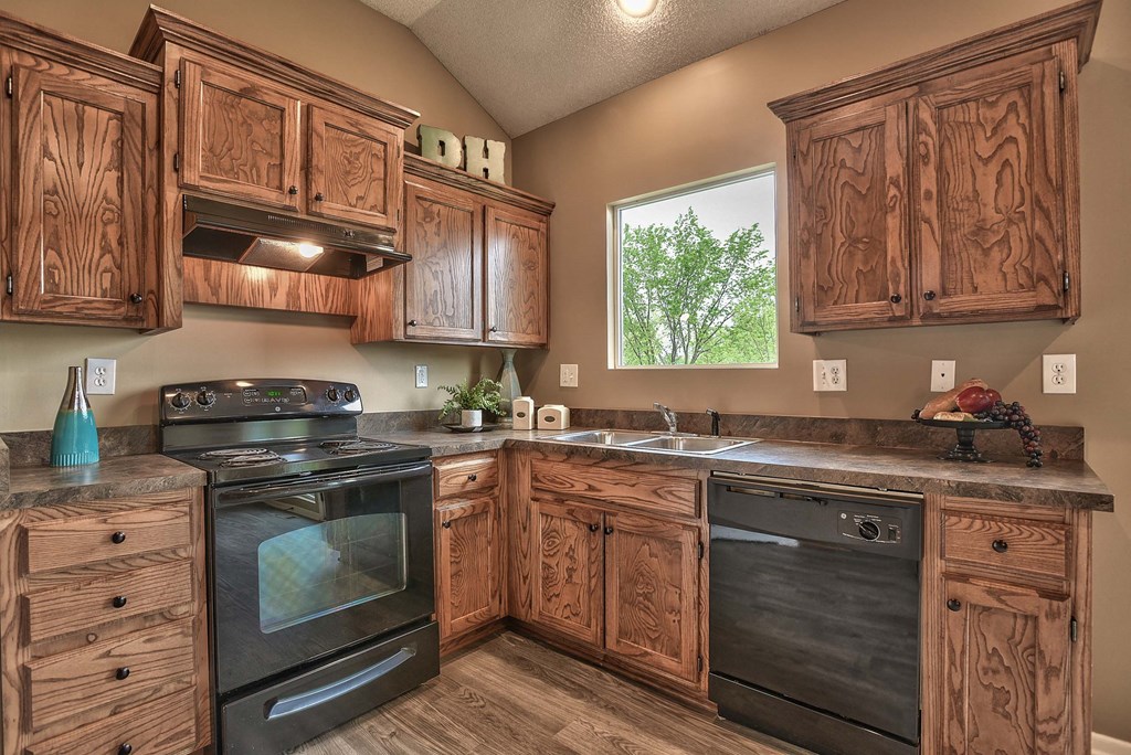 a kitchen with wooden cabinets and black appliances