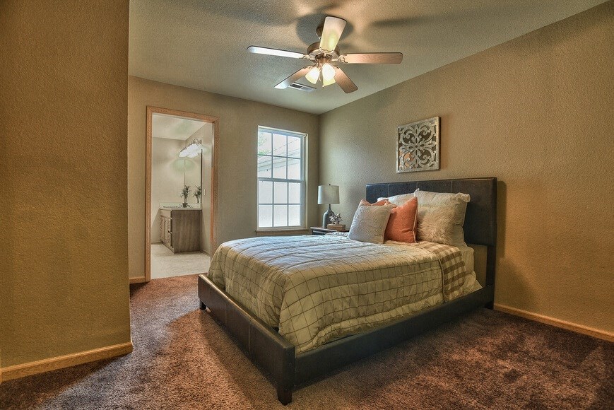 a bedroom with a bed and a ceiling fan