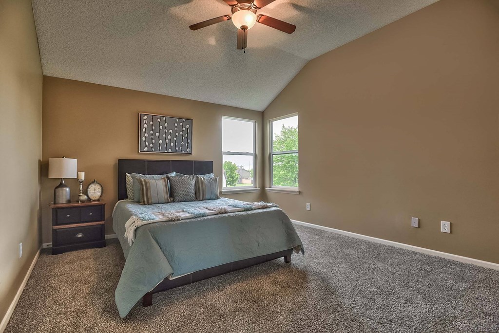 a bedroom with a bed and a ceiling fan