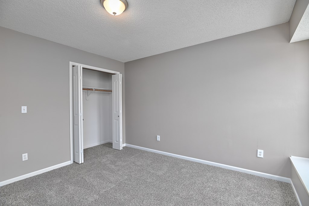 A room with a carpeted floor and a white door.